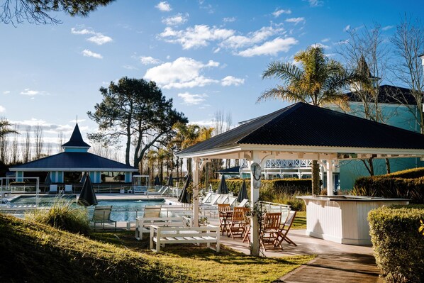A pool area with lounge chairs and a gazebo. - Howard Johnson Hotel & Convention Center Madariaga Carilo (Carilo)