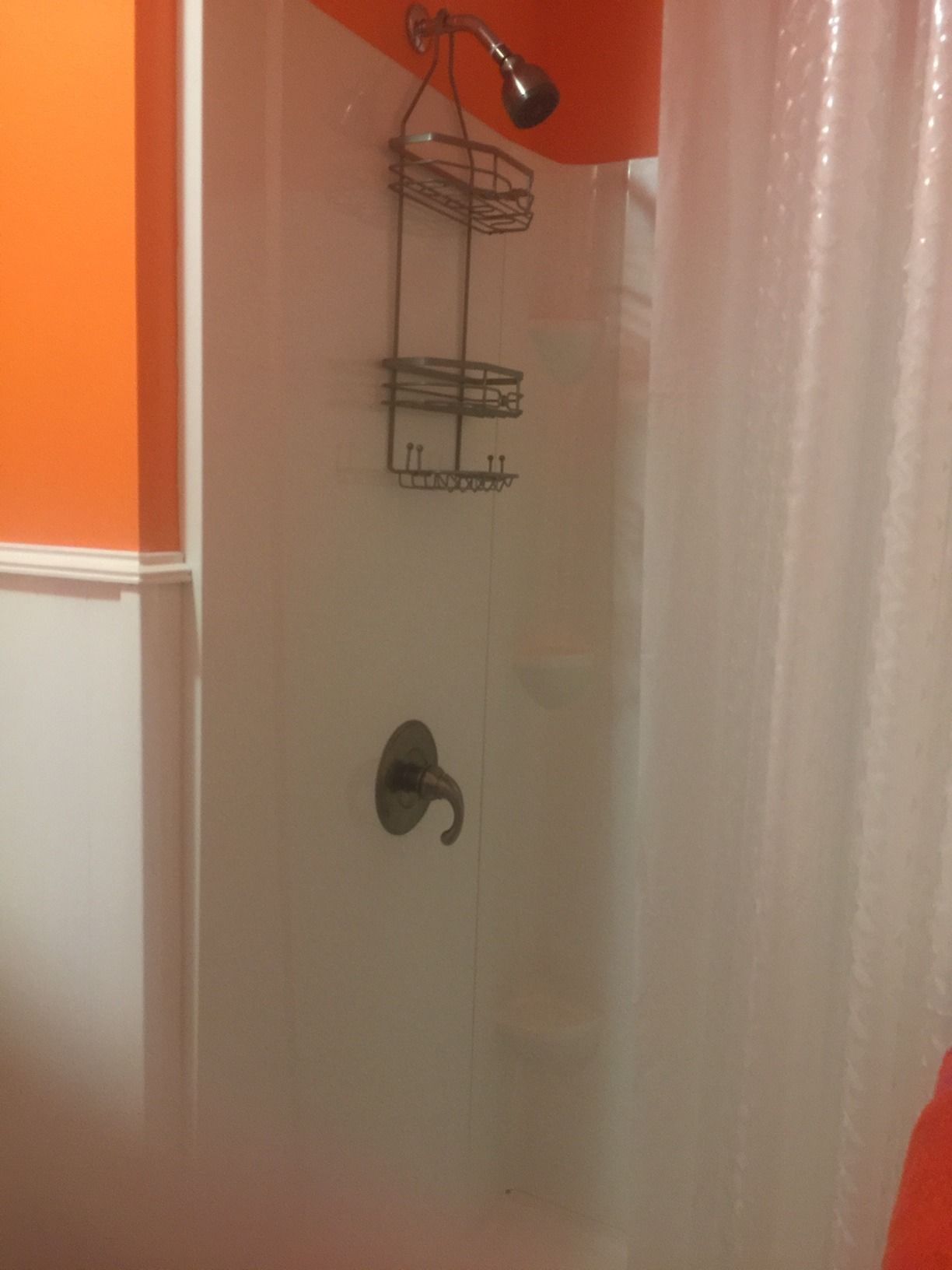Un baño con ducha, toallero y puerta.