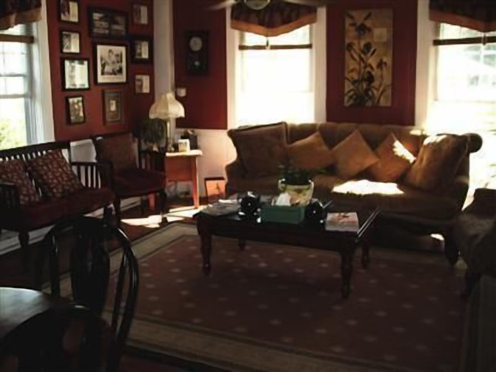 A cozy living room with a brown sofa, a wooden coffee table, and a patterned rug.