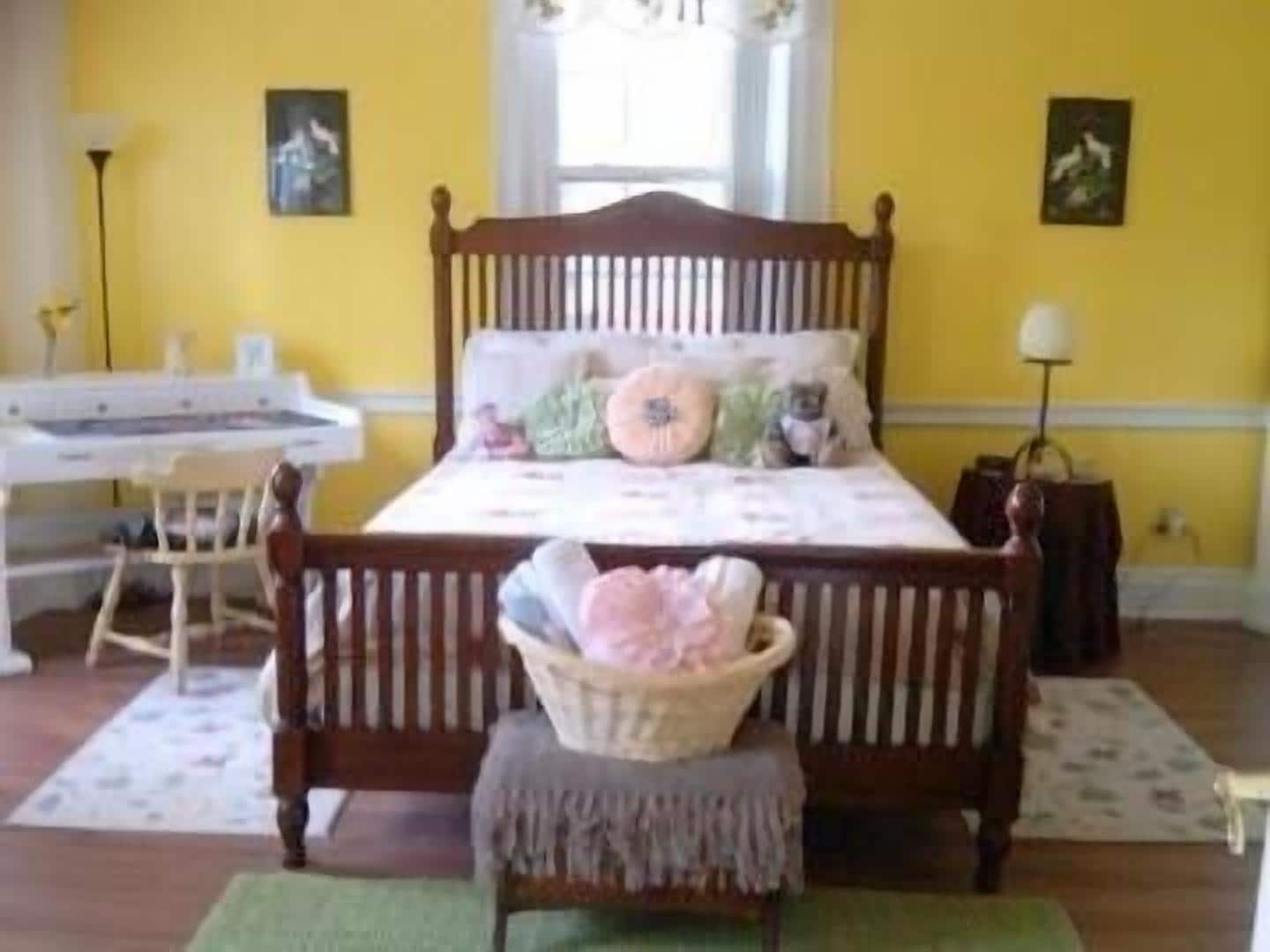 A bedroom with a wooden bed, a desk, and a chair.