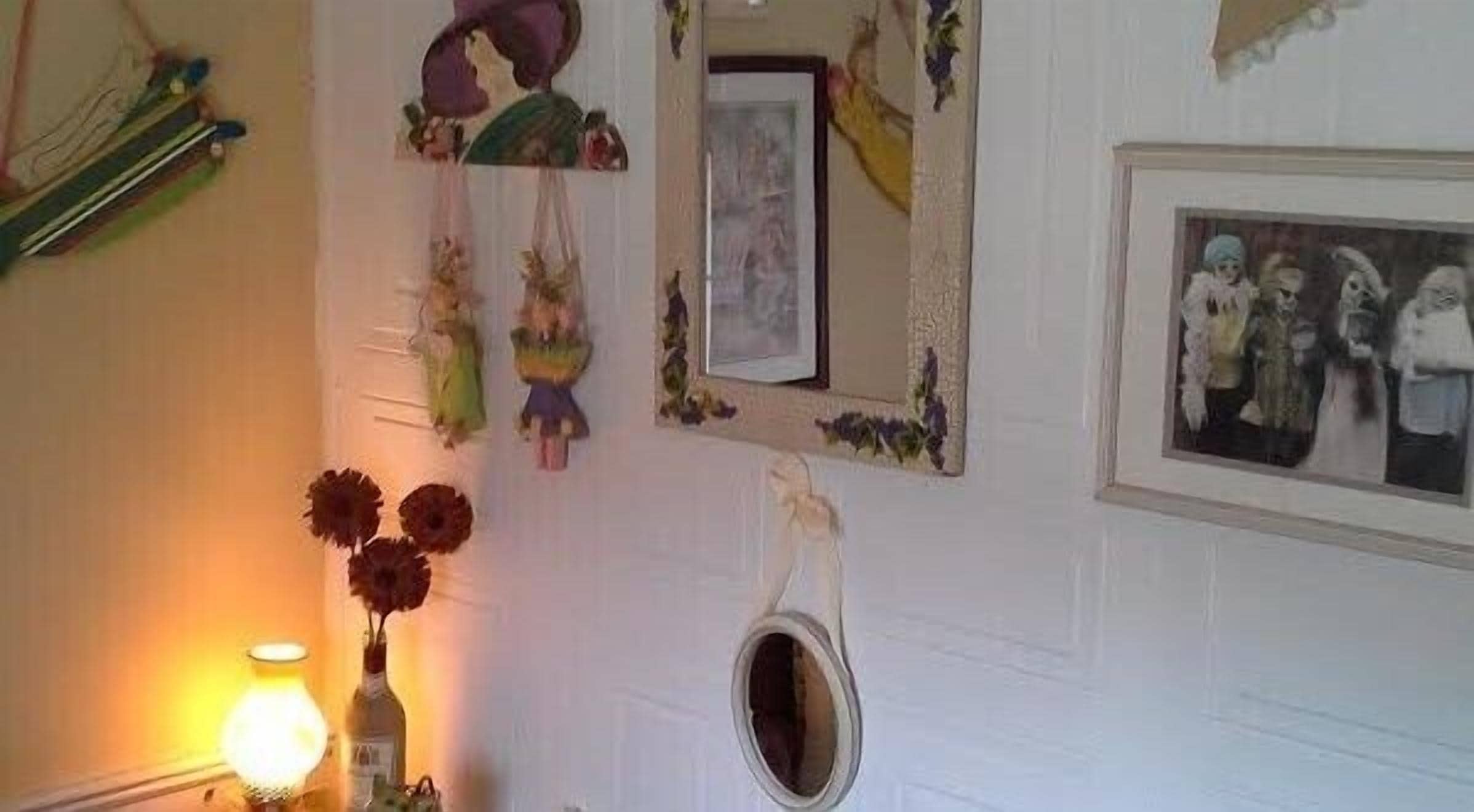 Un baño con espejo, lavamanos pequeño y retrete.