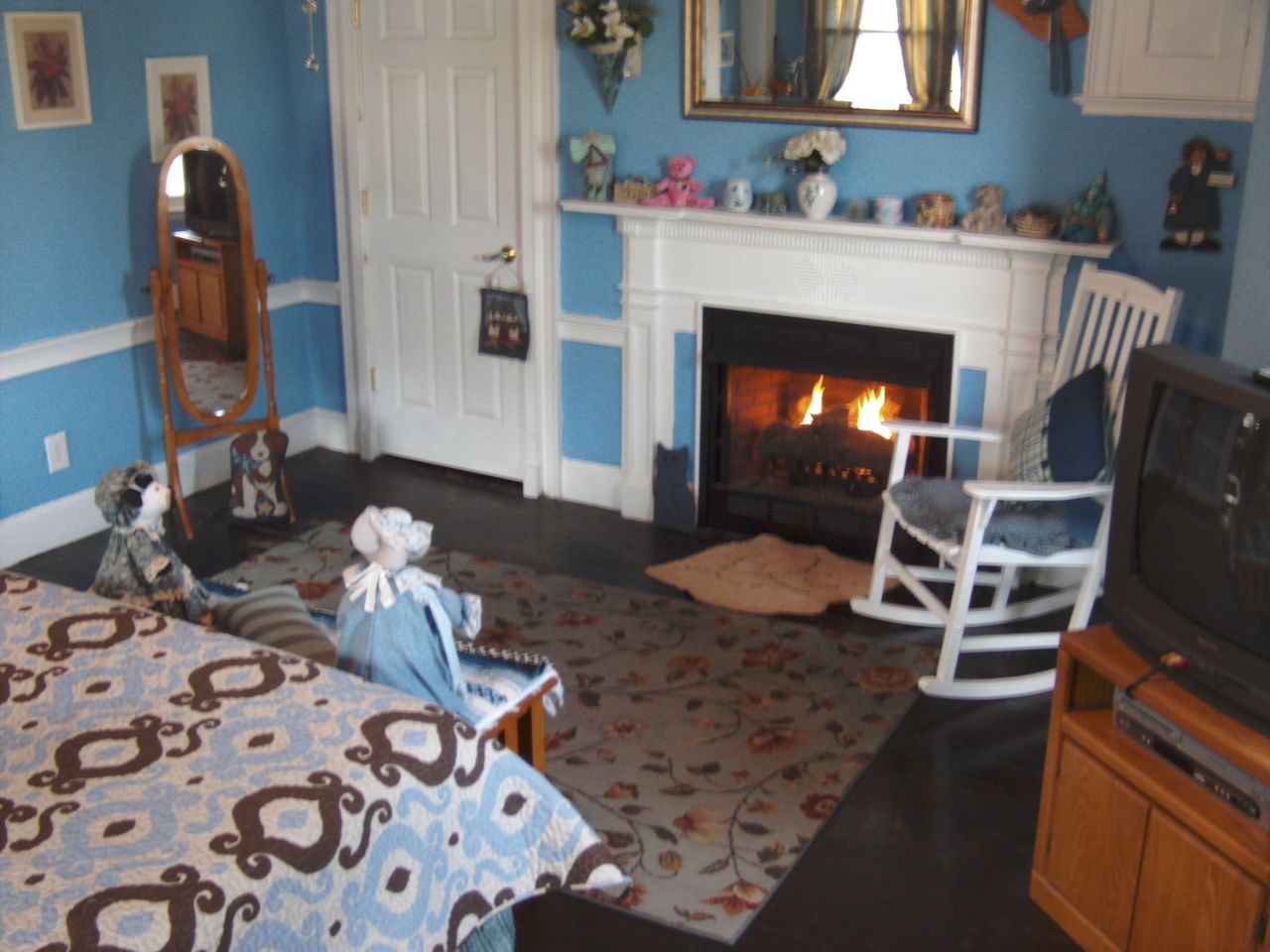 A living room with a fireplace, a television, and a patterned rug.