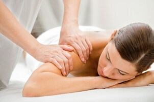 A person receiving a massage on a white towel.