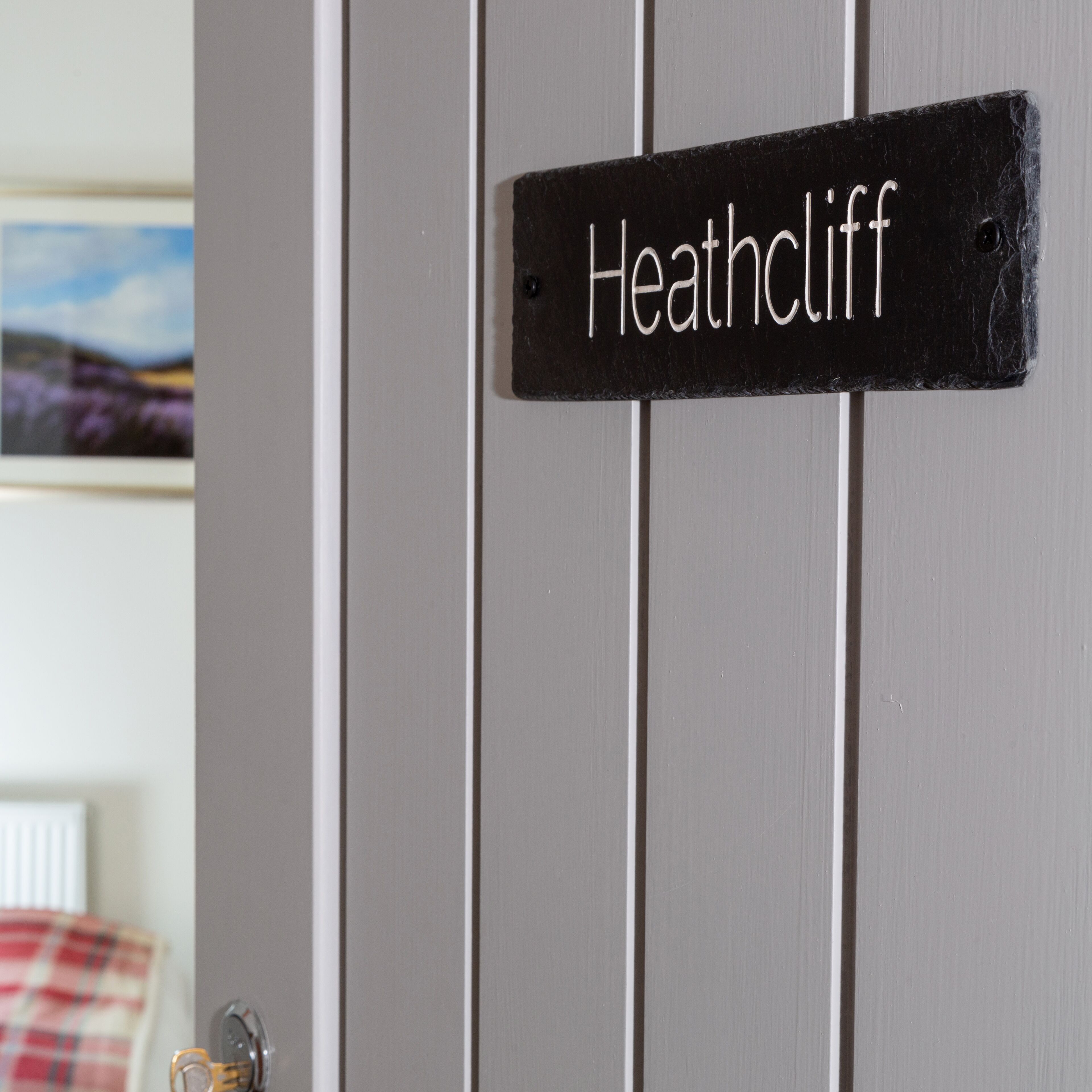 A door with a sign reading "Heathcliff" mounted on it.
