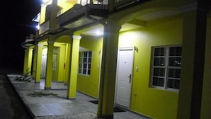A building with a yellow exterior, multiple doors, and a balcony. - Piarco Village Suites (Piarco)