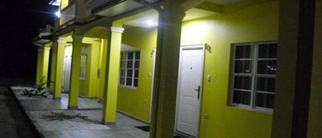 A building with a yellow exterior, multiple doors, and a balcony.