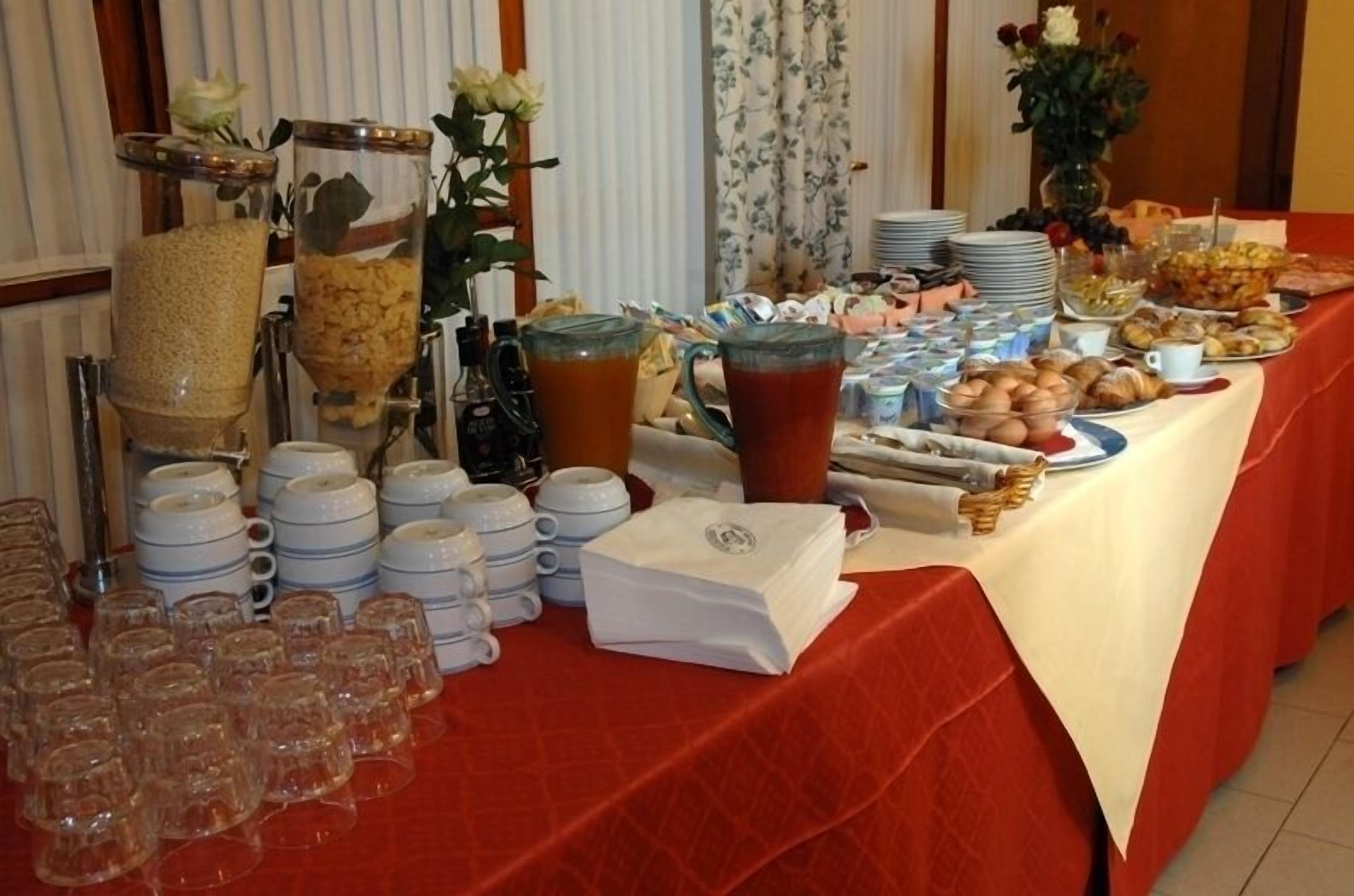 Una mesa de buffet con diversos alimentos, como frutas, pasteles y bebidas.