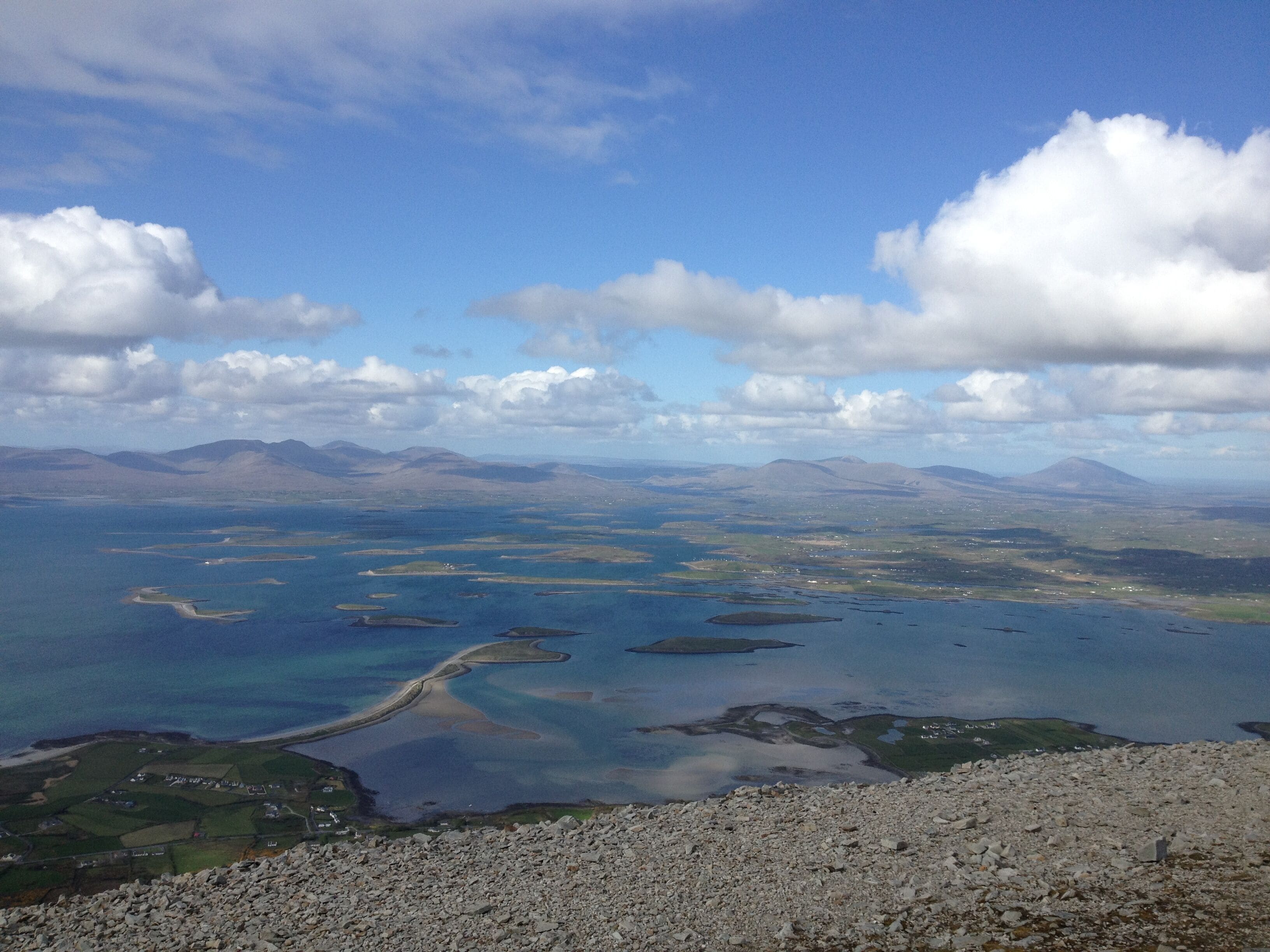 A coastal landscape with a clear sky, rocky terrain, and a winding water body.