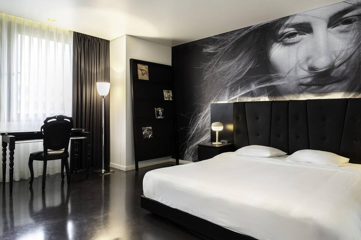 Una habitación de hotel moderna con una cama grande, un escritorio y una silla.