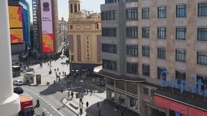 A city street with buildings, including a hotel with a visible sign. - Main Street Madrid (Madrid)