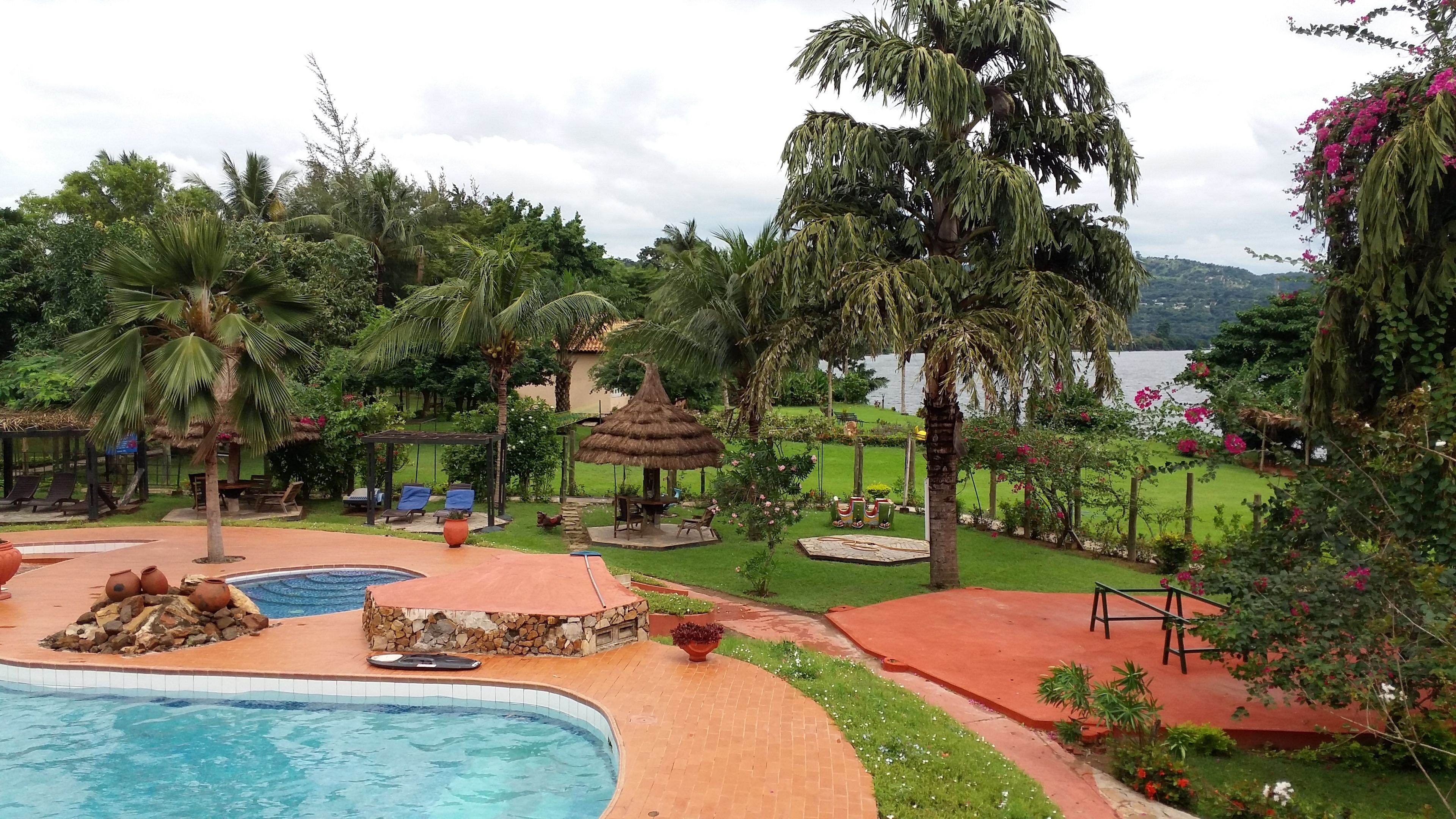 A pool area with a hot tub, lounge chairs, and a gazebo.