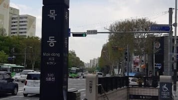 A street sign with multiple languages and directions, a bicycle parking area, and a traffic light.