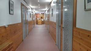Un pasillo con paneles de madera, una recepción y cuadros en las paredes.