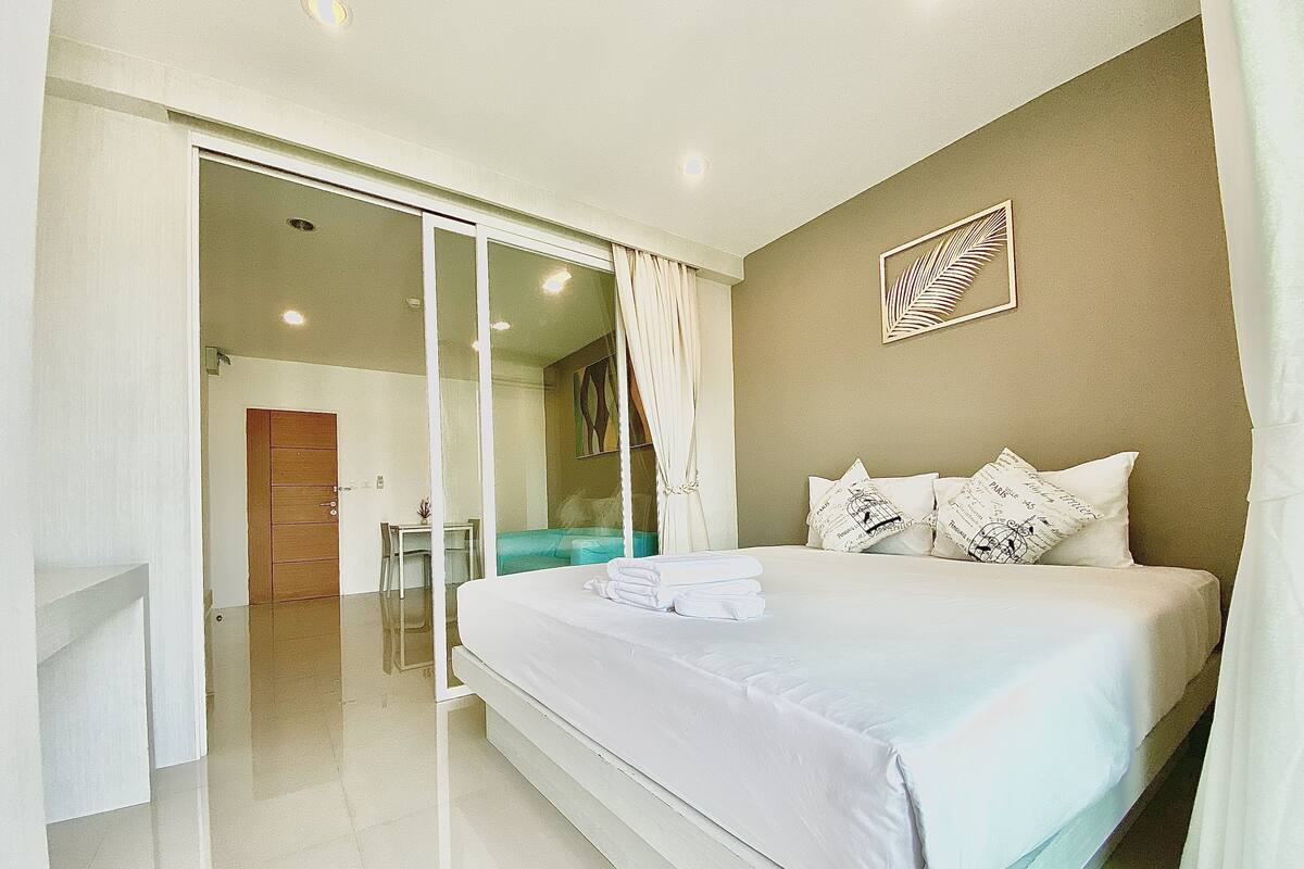 Ein Hotelzimmer mit Bett, Schreibtisch und einer Schiebetür zum Balkon.