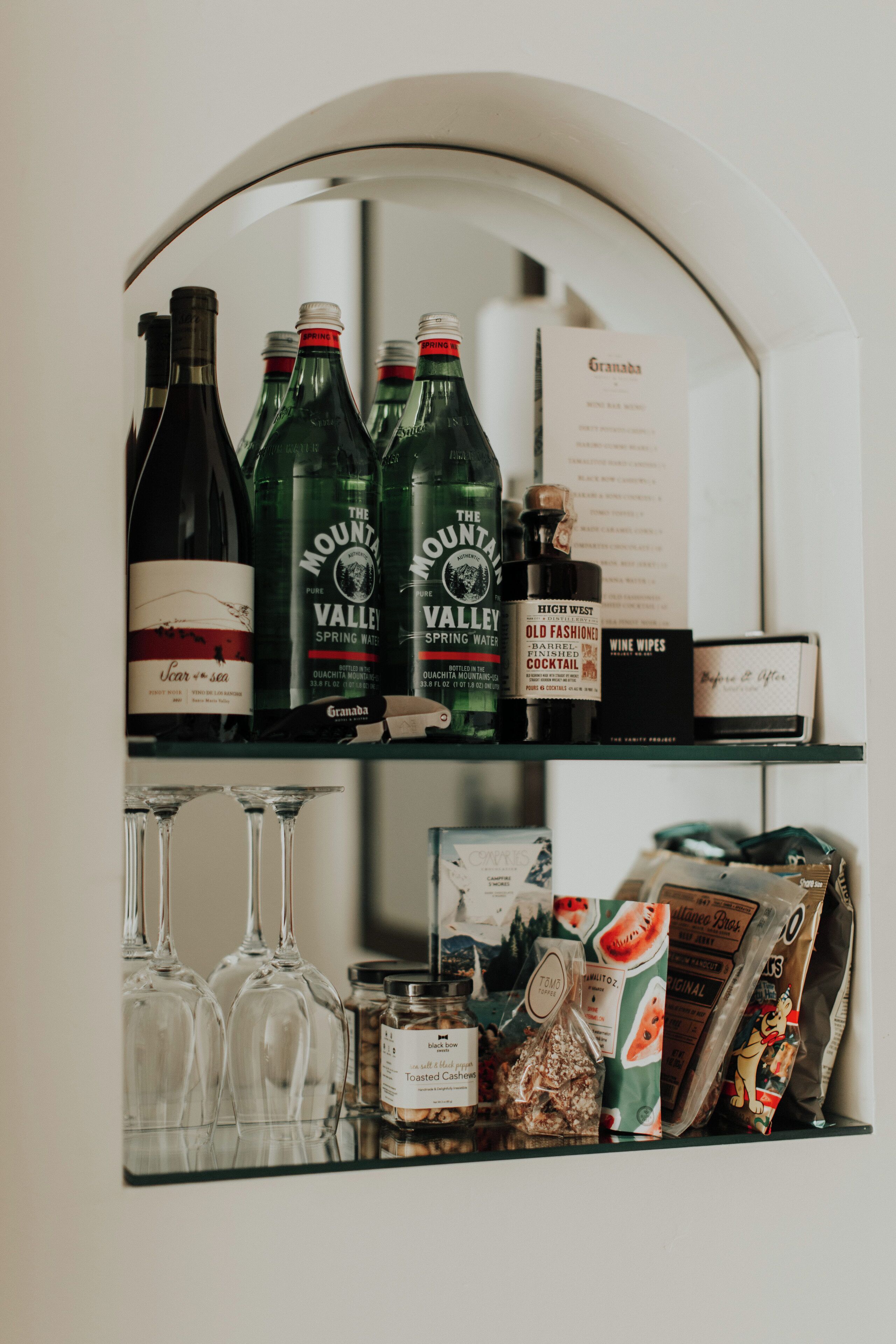 Eine Bar mit Weinflaschen, Gläsern und Gewürzen.