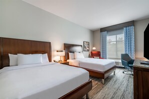 A hotel room with two beds, a desk, a chair, a lamp, and a large window with curtains. - Hilton Garden Inn Dayton South-Austin Landing (Miamisburg)