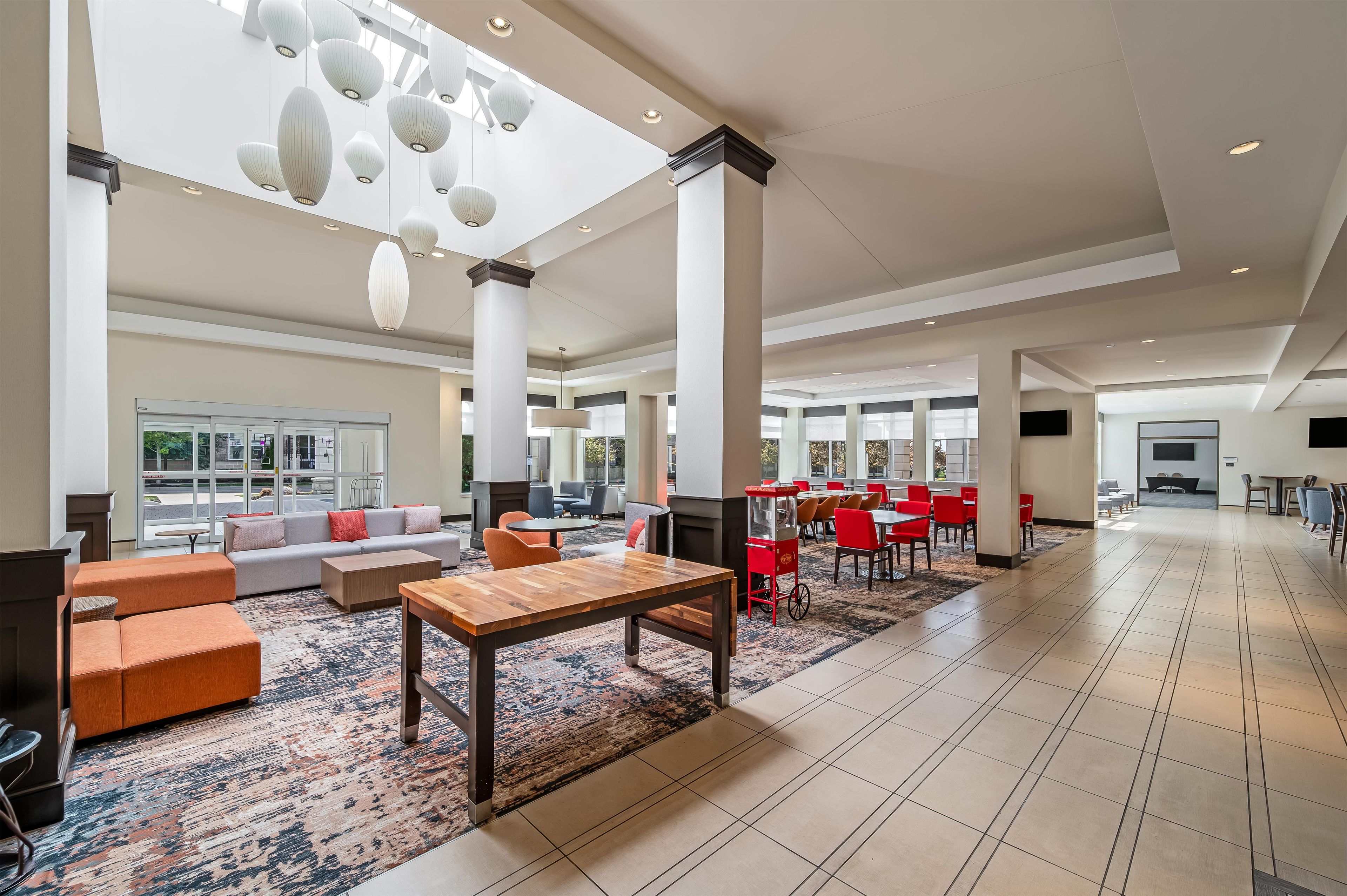 A spacious lobby with a seating area, a coffee station, and a large window providing a view of the outside.