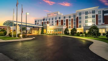 A Hilton Garden Inn with a modern architectural design, featuring a large entrance and a well-lit driveway.