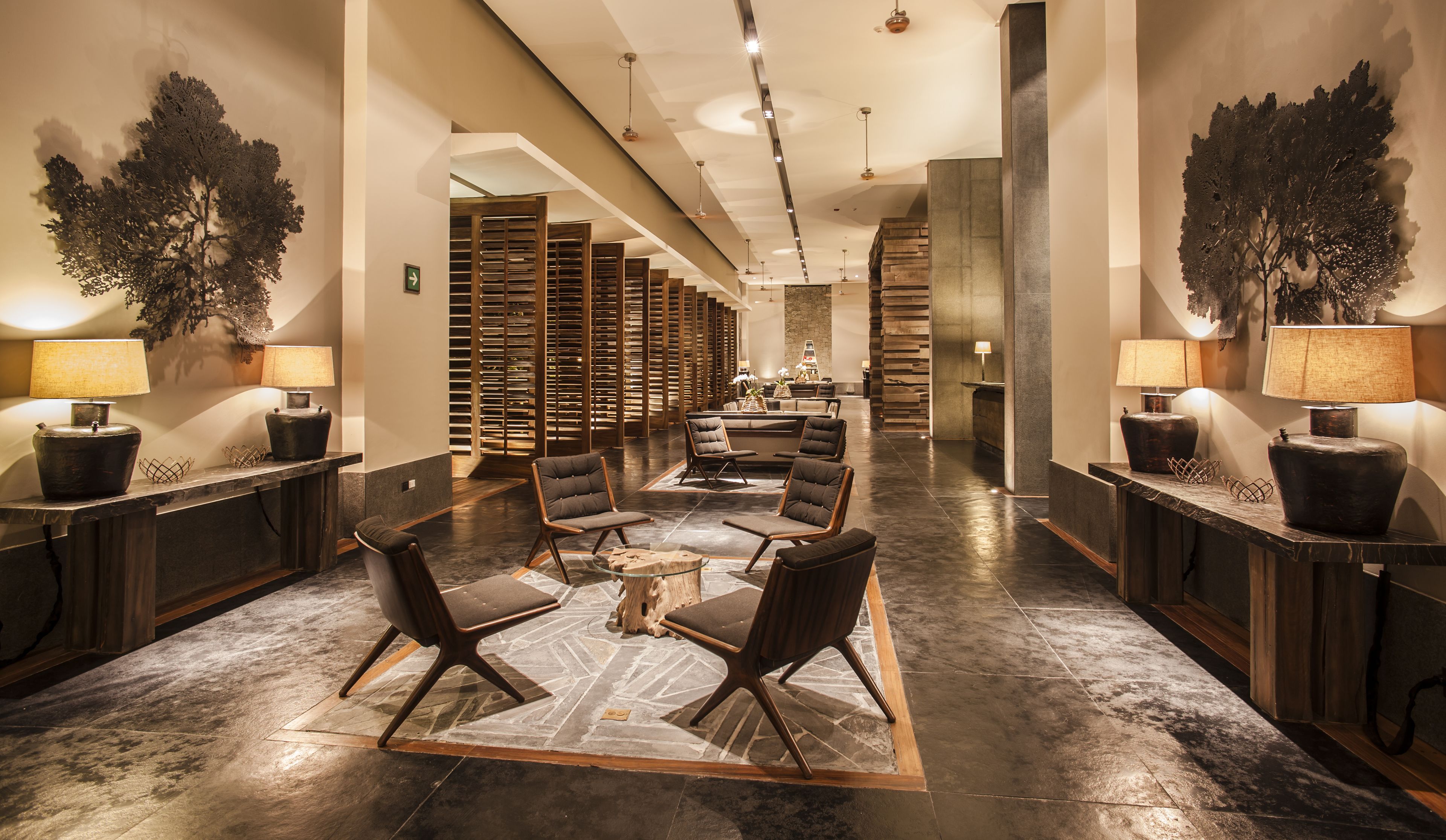 A spacious lobby with modern furniture, a central seating area, and a reception desk.