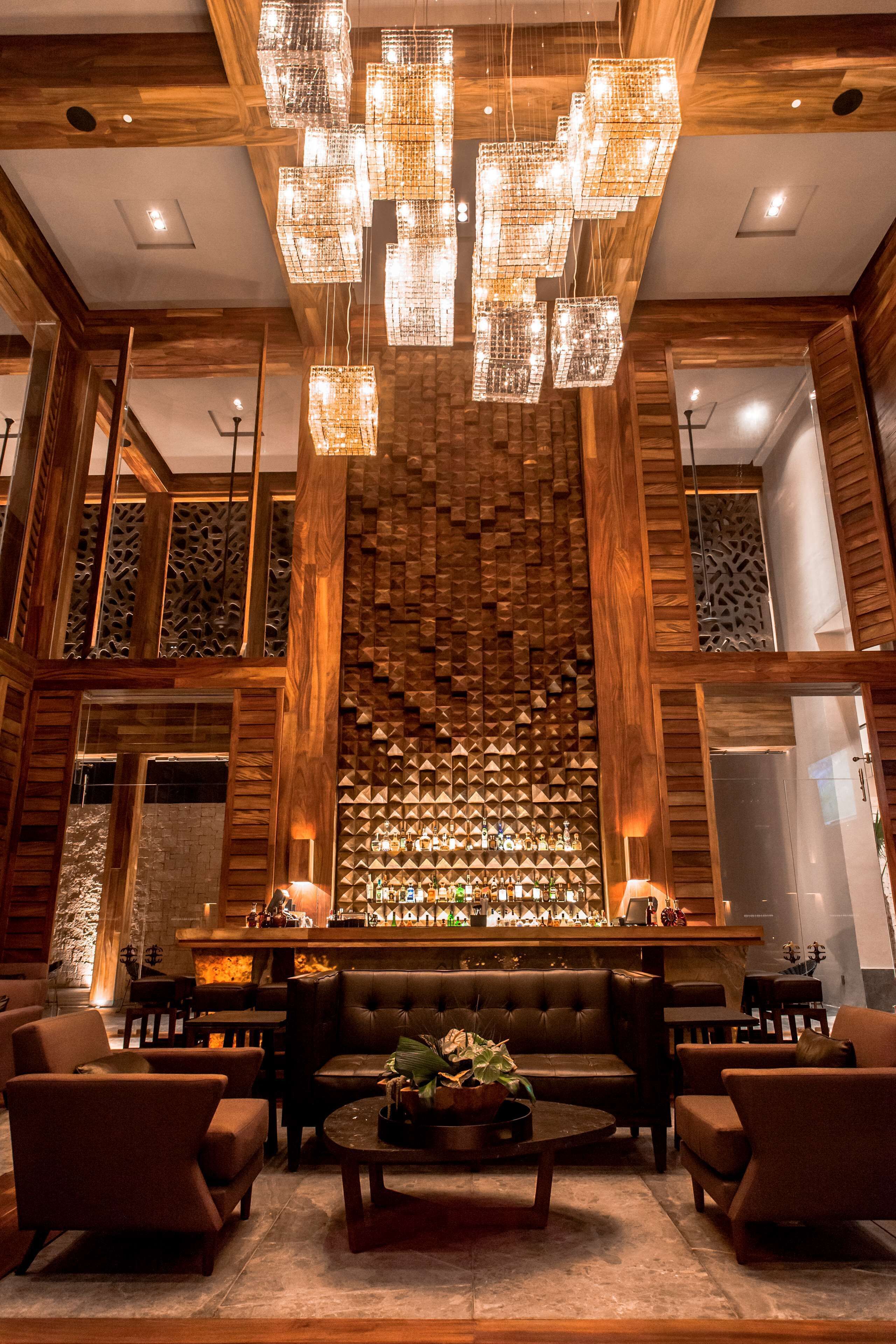 A lobby with a bar area, seating, and a decorative wall with geometric patterns.
