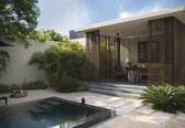 A modern outdoor pool area with a built-in seating area, surrounded by lush greenery and a minimalist architectural design.