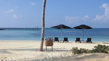 En privat strand, parasoller, badehåndklæder, dykning