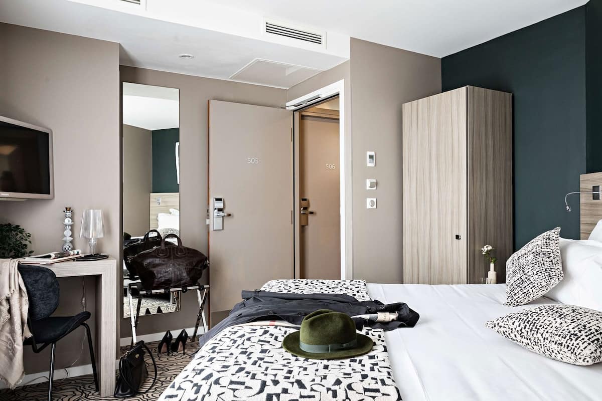 Une chambre d’hôtel comprenant un lit, un bureau, une chaise, une armoire et un téléviseur.