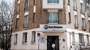 Un hôtel à plusieurs étages, doté d’une façade blanche, de nombreux balcons et d’une enseigne indiquant « Best Western ».