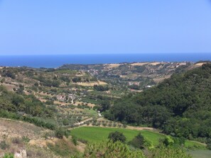 A panoramic view of a coastal landscape with rolling hills, vineyards, and scattered buildings. - Il Corbezzolo (Cupra Marittima)
