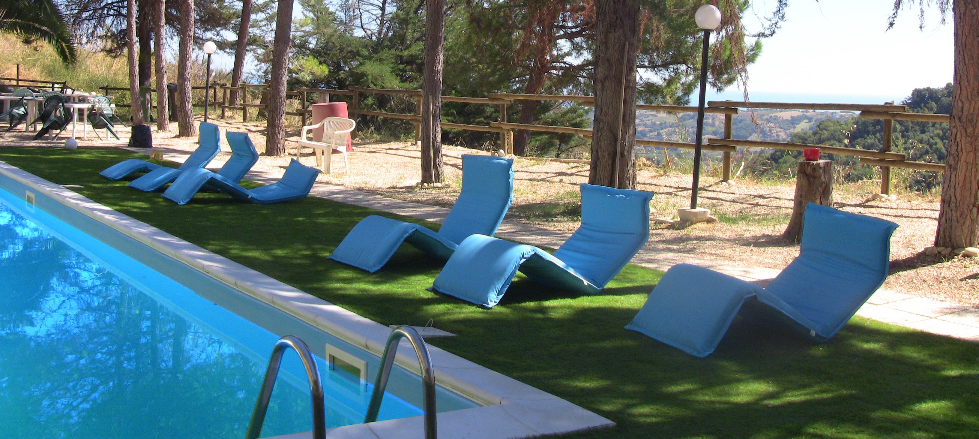A pool area with lounge chairs and a wooden deck.