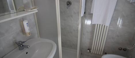 Un baño con lavabo, bidé y zona de ducha.