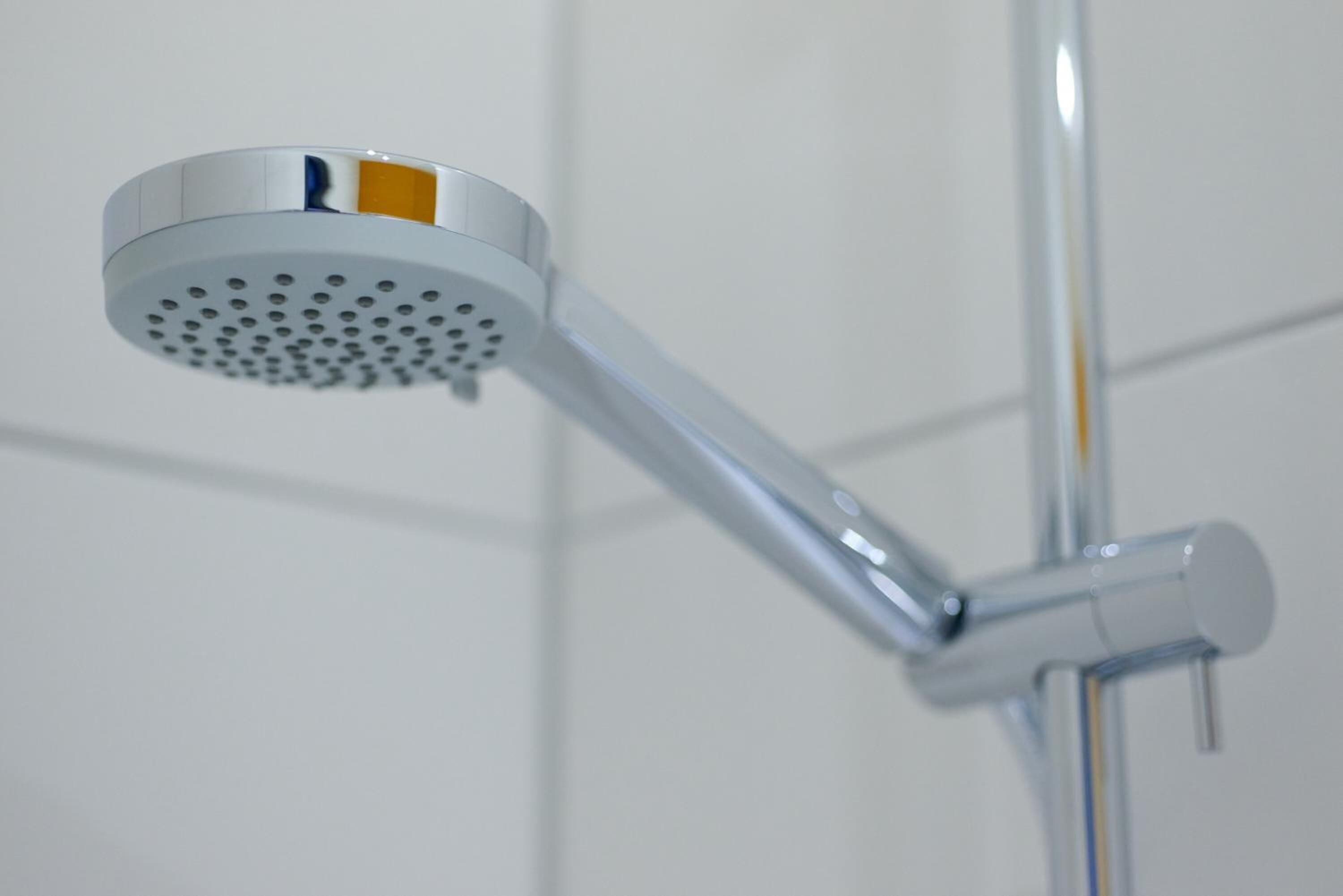 A showerhead with a circular spray head and a chrome finish.