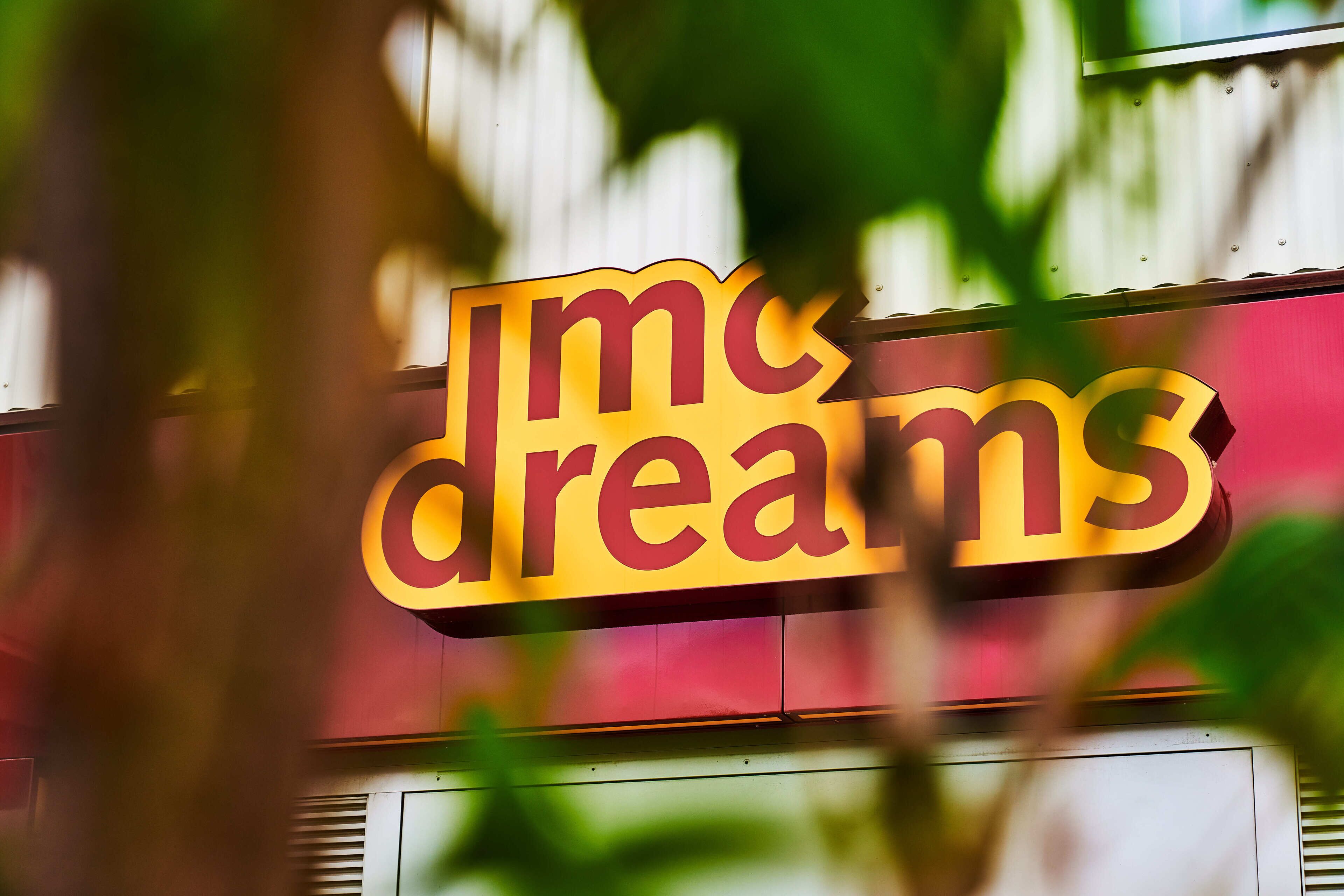 A sign with the text "IMc dreams" on a building facade.