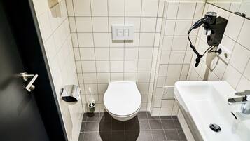 Ein kleines Badezimmer mit Toilette, Waschbecken und Handtuchhalter.