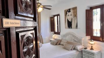 Un dormitorio con cama, mesita de noche y un cartel que indica el número de habitación.