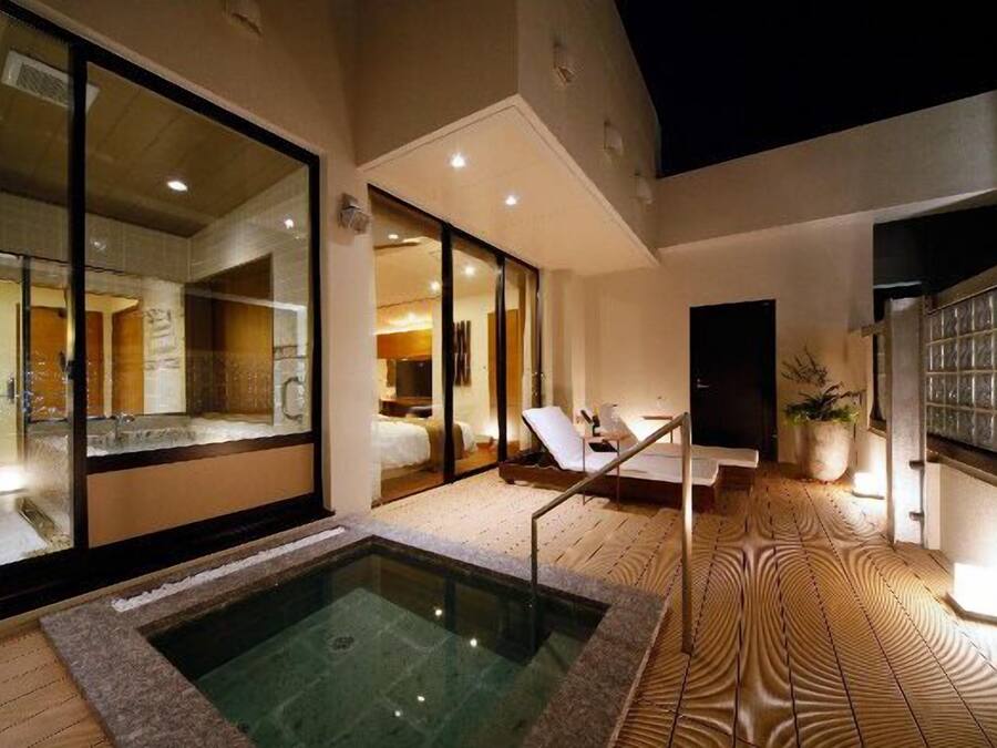 Une chambre d’hôtel moderne avec un balcon privé, un jacuzzi et une vue sur la cour intérieure.