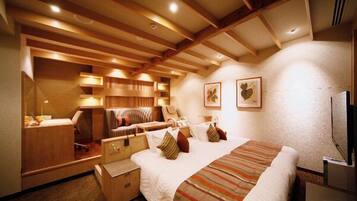 A hotel room with a large bed, wooden ceiling beams, a desk, and a chair.
