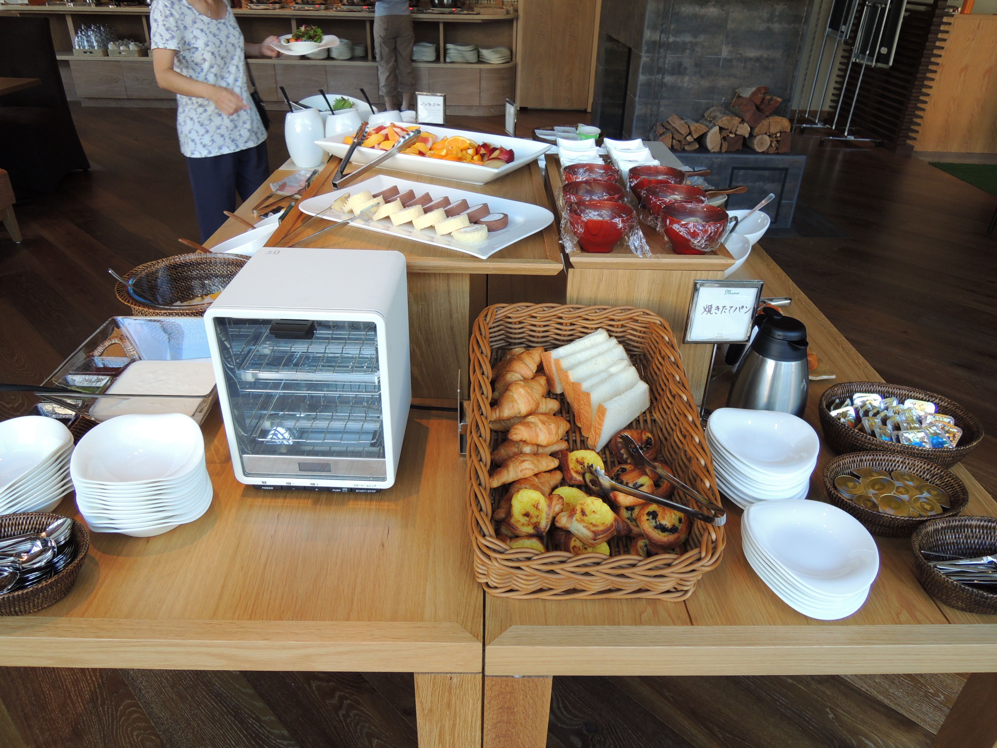 A buffet setup with various food items, serving trays, and a coffee machine.