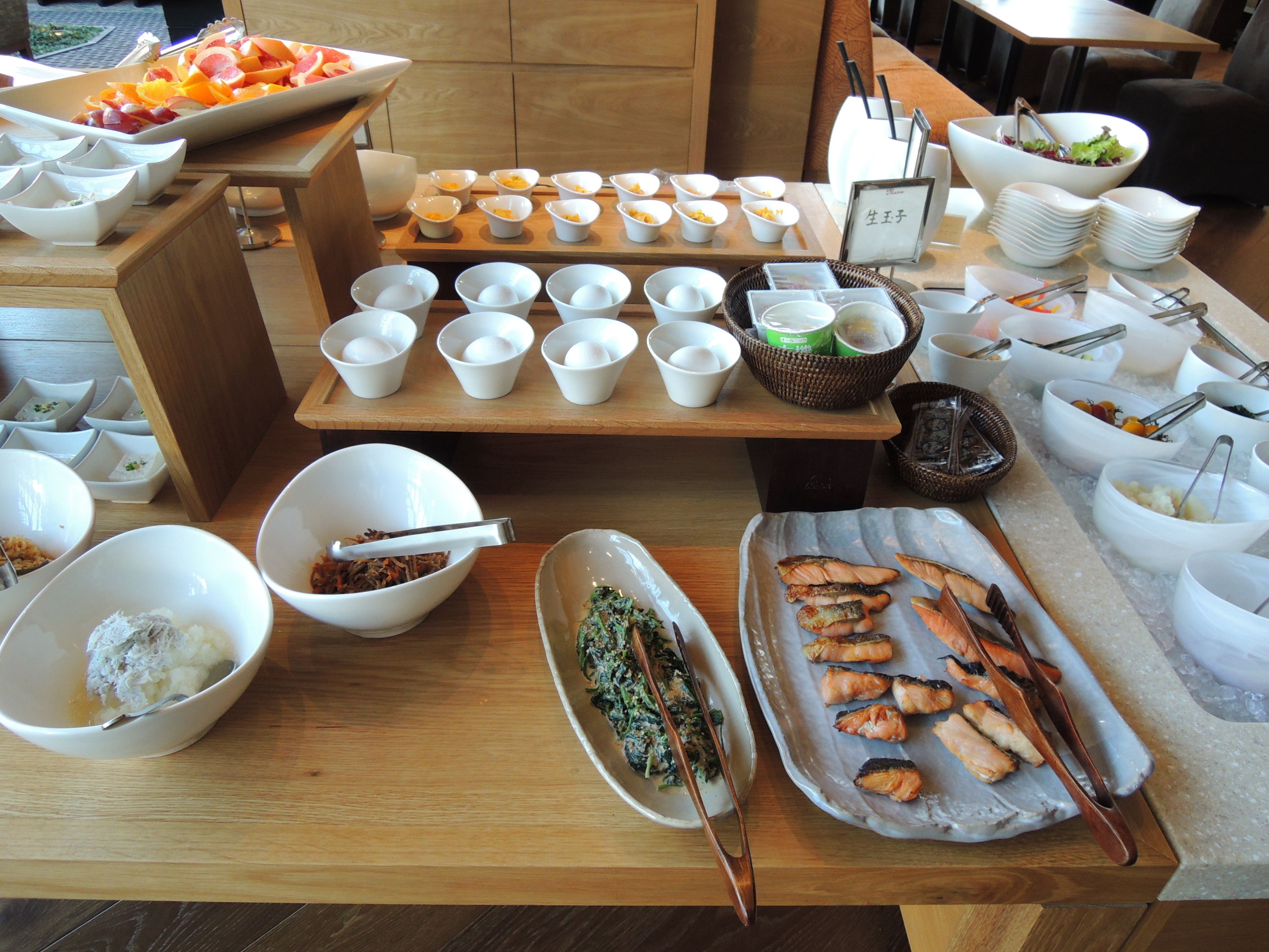 A buffet setup with various food items and serving utensils.