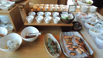 A buffet setup with various food items and serving utensils.