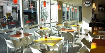 Un restaurante con terraza, sillas y mesas modernas.