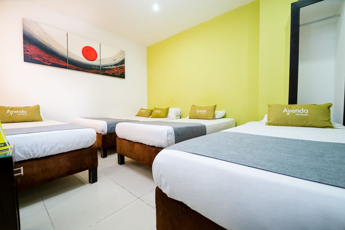 A hotel room with three beds, each with a pillow labeled "Ayenda."