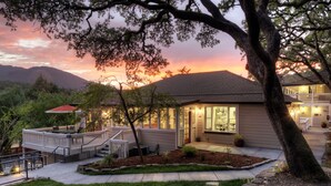A house with a deck, a front porch, and a well-maintained lawn. - Olea Hotel (Glen Ellen)
