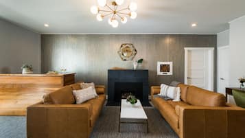 A living room with a fireplace, two sofas, a coffee table, and a decorative ceiling light.