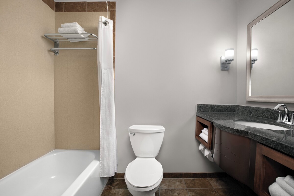 Ein modernes Badezimmer mit Badewanne, Toilette und Waschtisch.
