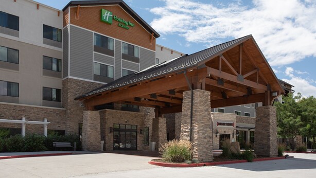 A Holiday Inn & Suites building with a covered entrance, brick facade, and multiple windows. - Holiday Inn Hotel & Suites Durango Downtown by IHG (Durango)