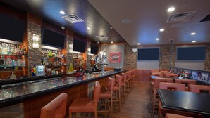A bar area with a long counter, multiple seating options, and a variety of liquor bottles. - Holiday Inn Hotel & Suites Durango Downtown by IHG (Durango)