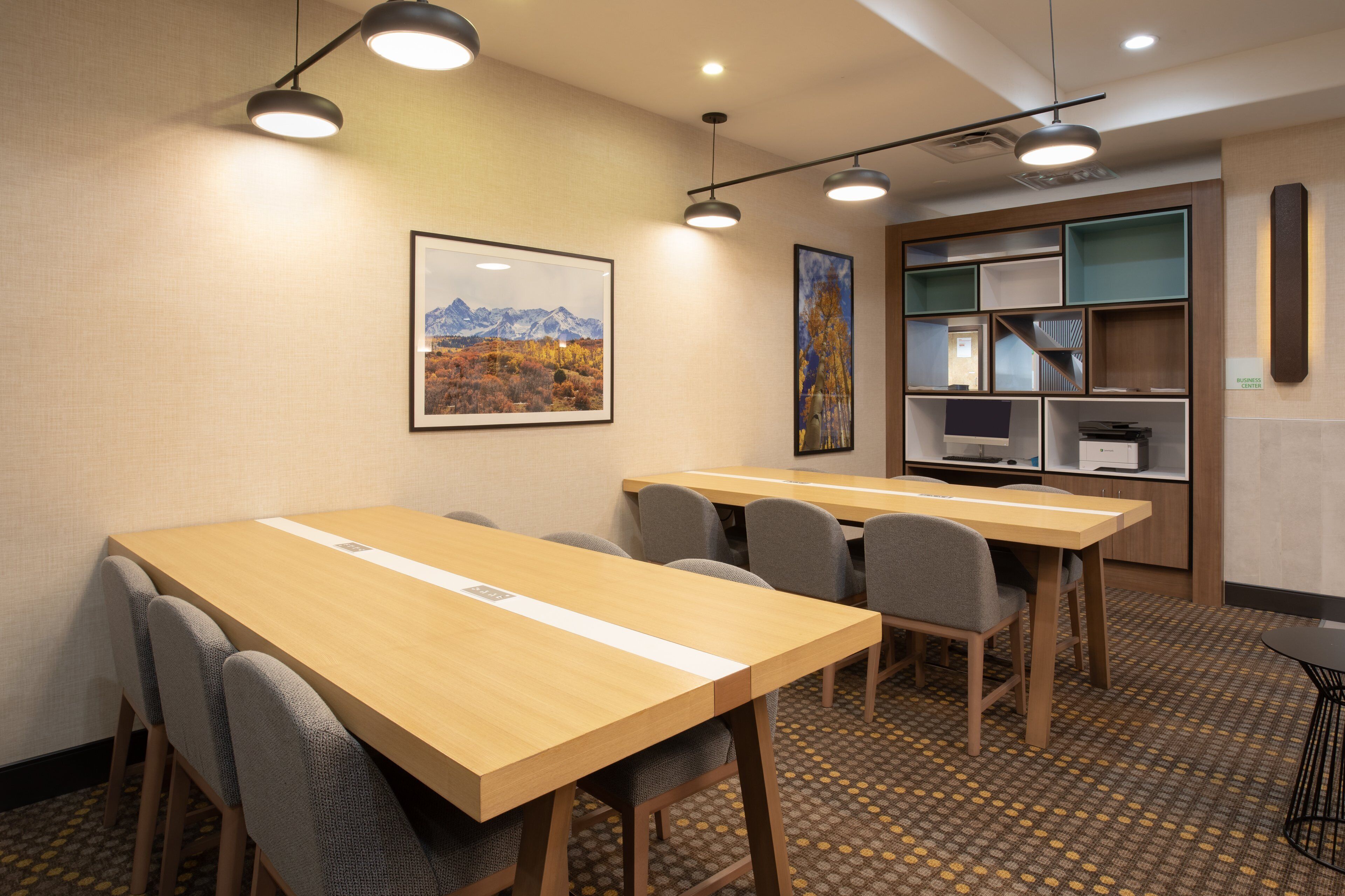 A conference room with a long table, chairs, and a projector screen.