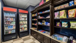 A self-service snack and beverage area with refrigerated drinks and a variety of snacks.