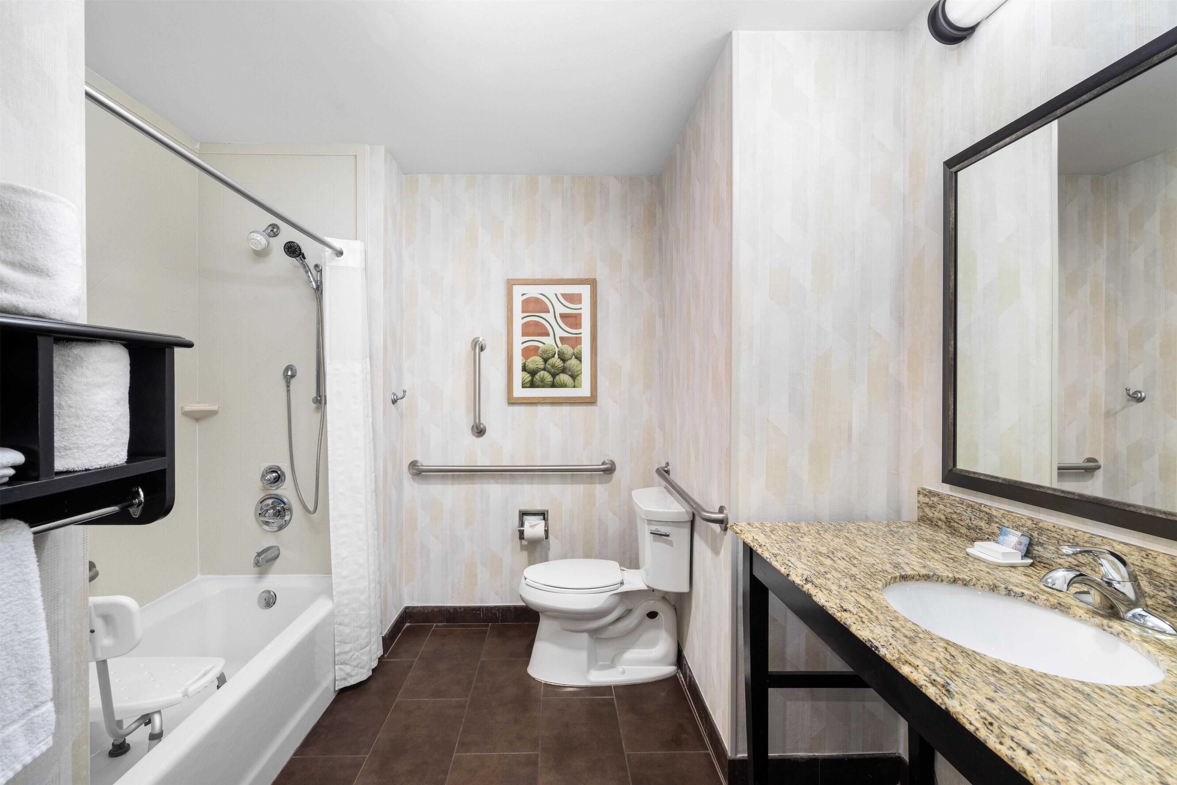 A modern bathroom with a bathtub, toilet, and sink.